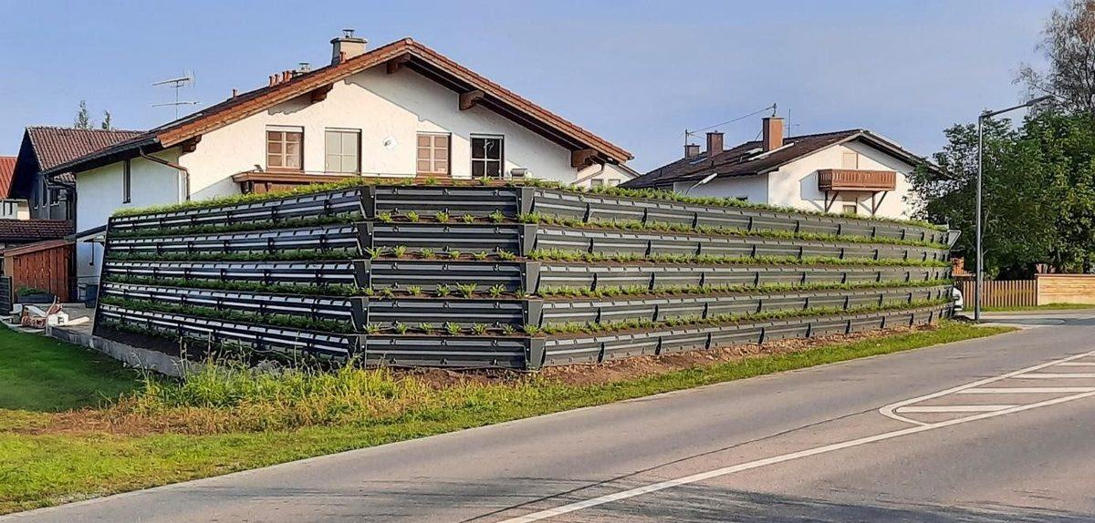 Pantalla PANACOR VG-E recién montada y rellena de tierra junto a una vivienda